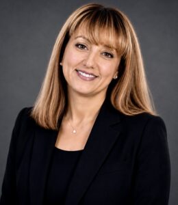 Gamze Zeytinci smiling and wearing a black shirt and black blazer